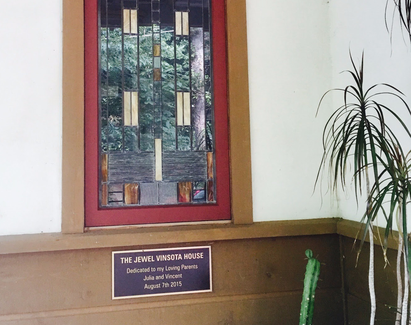 Leaded glass window with a plaque that reads "The Jewel Vinsota House: Dedicated to my Loving Parents Julia and Vincent. August 7 2015"